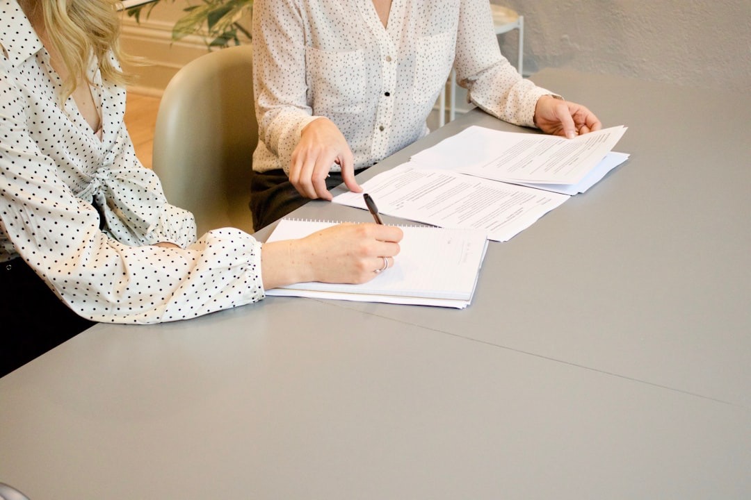 Two people discuss documents at a table.