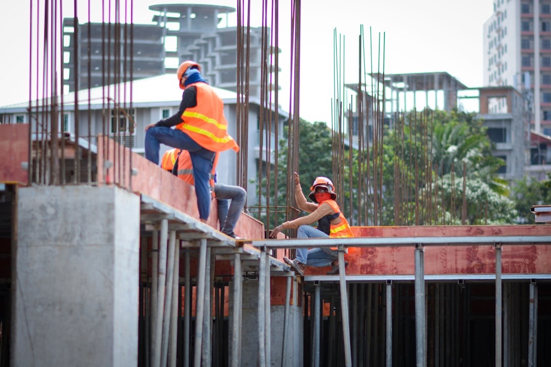 Construction workers on unfinished concrete building structure.